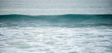 Okyanustaki dalgalar. Turkuaz deniz dalgaları. Mavi ve turkuaz rengi köpüklü güzel deniz dalgaları