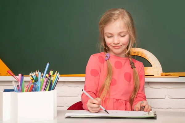 学校概念 孩子在写课本 小学生在小学做作业 在教室里学习的小女孩 — 图库照片