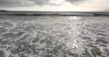 Denizin dalgaları gibi. Okyanusun suları, kumsalda ve manzaralı kıyı şeridinde dönüyor.