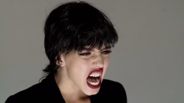 Bağıran ağız, çığlık atan yüz. Kızgın, hayal kırıklığına uğramış kadın yüzü başka tarafa bakıyor. Öfkeli kadın öfkeyle bağırıyor.