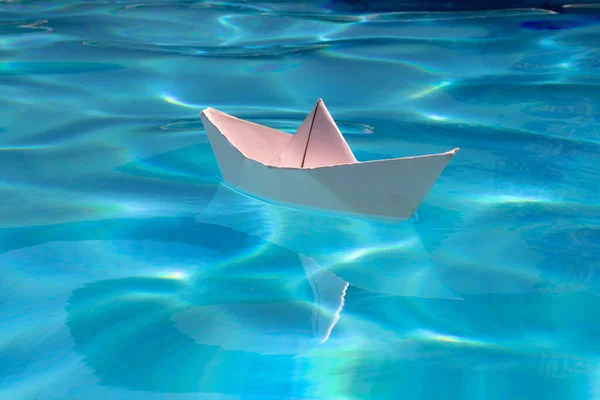 Cruise liner paper art. Paper boat sailing away on sea surface water background. Origami toy ship as a symbol of discovery, mission, freedom and voyage