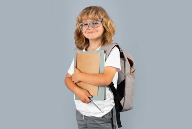 Küçük okul öğrencisi kitapları tutuyor. Çocuk eğitim konsepti. Okul üniformalı çocuk. Gülümseyen mutlu okul çocuğunun portresi. Pozitif duygular