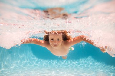 Child swim under water in sea. Kid swimming in pool underwater. Happy boy swims in sea underwater. Children in water. Kids beach fun