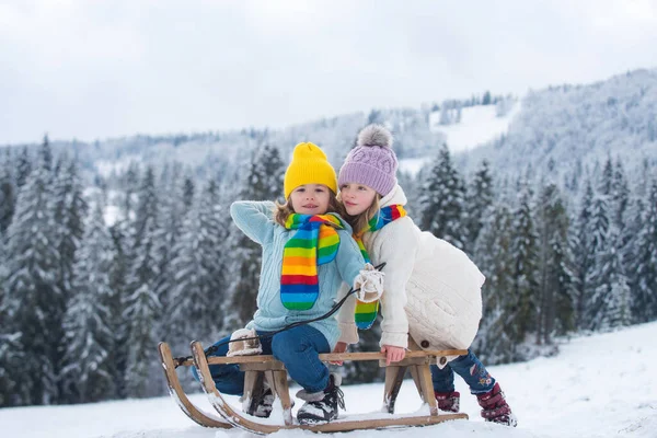 雪の森の中で少年少女が眠っていた 屋外の冬の子供たちはクリスマスと新年を楽しんでいます そりに乗る子供たち クリスマスの風景 — ストック写真