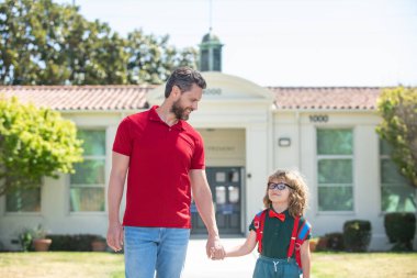Baba ve oğul okuldan döndükten sonra babalarıyla koşuyorlar. Okul çocukları eğitim ve açık hava konsepti