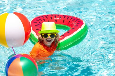 Tatlı komik çocuk yüzme havuzunda oyuncak yüzme yüzüğüyle rahatlıyor yaz tatilinde tropikal bir otelde eğleniyor. Yaz tatili, çocuk havuzda yüzüyor.