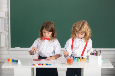 Çocukların yaratıcı gelişimi. Resim okulu öğrencileri resim ödevi yapıyor. Çocuklar ilkokulda resim çiziyor.