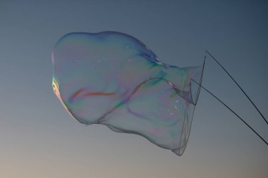 Dev renkli baloncuk. Mavi gökyüzünde büyük bir sabun köpüğü. Büyük ip sabun köpükleri yapıyorum.