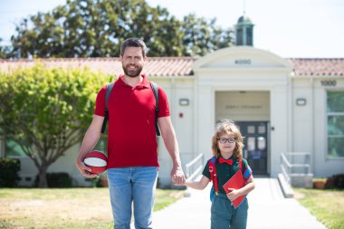 Açık hava okulu. Baba ve oğul okuldan dönüyorlar. Okul, aile, eğitim ve açık hava konsepti