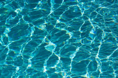 Su arka planı, dalgalanma dalgaları. Mavi yüzme havuzu deseni. Deniz yüzeyi. Yüzme havuzunda su ve güneş yansıması. Kopyalama alanı olan pankart