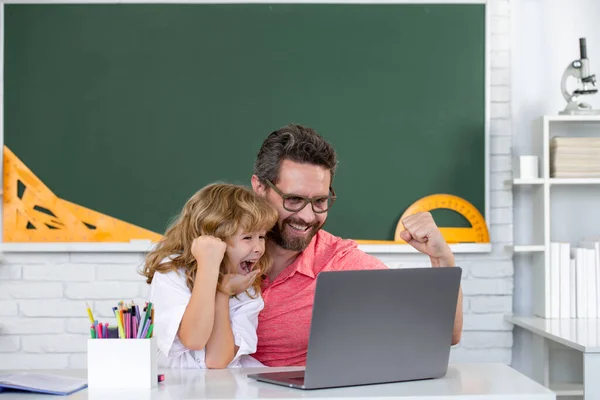 Kid boy learning with teacher. Funny little boy study with father in class on blackboard. Child from elementary school