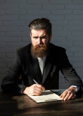 Man teaching near chalkboard in classroom. Exam in college or university. Teacher or professor at classroom. Satisfied serious mature teacher. Mature professor, middle aged teacher man