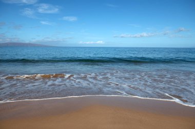Plaj geçmişi. Kumlu sahilde sakin, güzel bir okyanus dalgası. Tropikal deniz manzarası