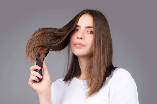 年轻女子梳理健康自然光泽的头发 隔离在工作室 美发护理 — 图库照片