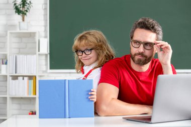 Teacher and pupil boy learning in the classroom. Teacher and little student portrait, teachers day