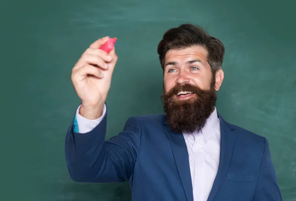 Portrait of a funny teacher or professor near blackboard. Thinking serious mature teacher. Mature professor, middle aged teacher, bearded man. Teachers day