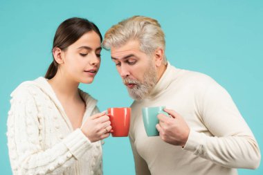 Funny couple drinking tea. Morning cup, coffee mug, people on isolated background with copy space. Surprised people hold mug with hot drink