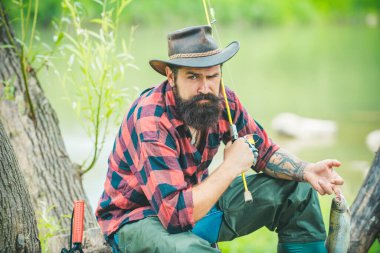 Balıkçı, dağ nehrinde olta balıkçılığı yapıyor. Ormandaki nehirde alabalık avlayan bir balıkçı.