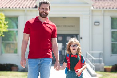 Baba oğlunu destekliyor ve motive ediyor. Çocuk ilkokula gidiyor.