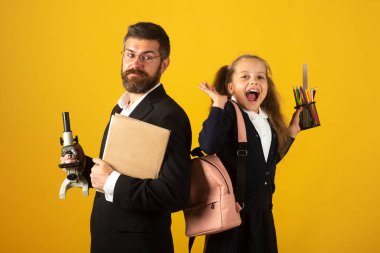 Back to school, student girl with uniform. Cheerful smiling little girl in school uniform having fun in studio. Portrait of amazed excited happy pupil school girl and tutor with success having fun