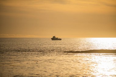 Günbatımında deniz manzarası ve tropikal plaj ya da tatil ve tatil için gün doğumu. Sudaki güneşin yansıması ve kumsaldaki kum.