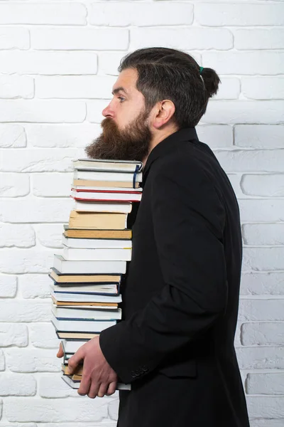 Portrait of a funny teacher or professor with book stack. Thinking serious mature teacher. Books stacked fall. Mature professor, middle aged teacher, bearded fun man
