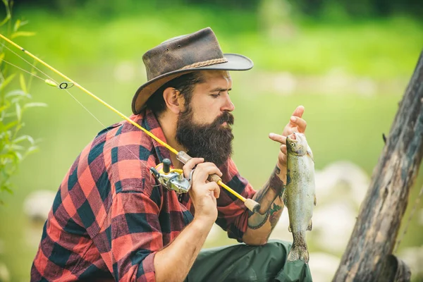 Portrait of fisherman caught a fish. Man fishing on river