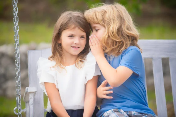 Niño Susurra Oído Una Chica Encantadora Hermano Hermana Jugando Parque —  Fotos de Stock