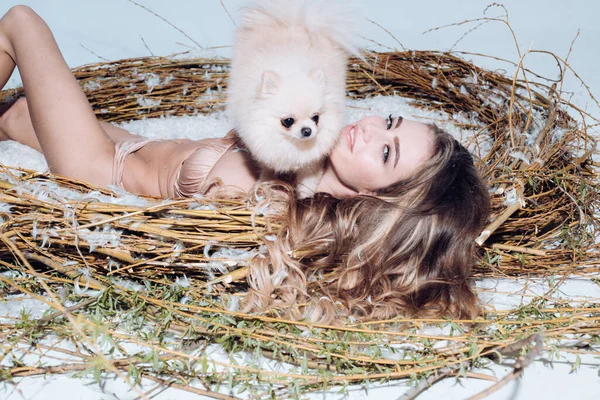 Fashion girl with dog. Beautiful woman with blond hair, posing with cute Yorkshire terrier dog
