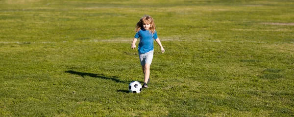 Boy kicking football ball. Soccer kid. Kids play football on summer stadium field. Little child boy kicking ball. Football sport training for children. Football little champion. Banner.