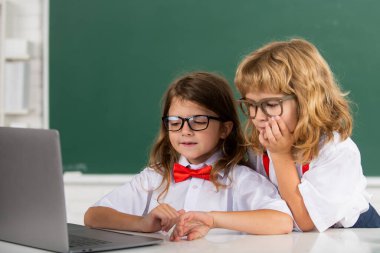 Okul arkadaşları birlikte öğreniyor. Mutlu kız ve erkek okul arkadaşları. İki okul çocuğunun portresi. İlkokulda sınıf arkadaşları, genç öğrenciler.