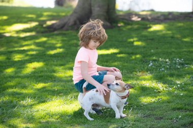 Köpekli mutlu çocuk. Dışarıda evcil hayvanlarıyla oynayan çocuk portresi. Çocuk köpeği okşuyor.
