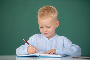 İlkokulda ders sırasında tahtaya yakın bir öğrenci portresi. Okuldaki ilkokul öğrencisinin komik yüzü.