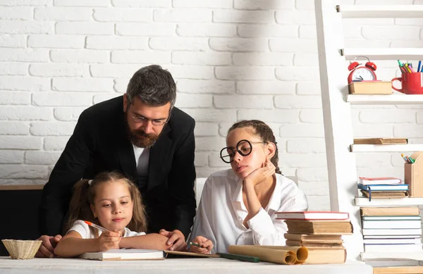 学校での父親の家庭教師と学校の子供の娘の肖像画 読書と執筆 パパは教室で女子生徒を教えてる — ストック写真