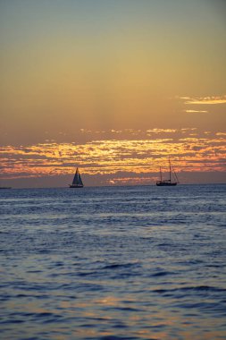 Altın dramatik gökyüzü manzaralı deniz üzerinde gün batımı. Gün batımı gökyüzü olan sakin bir deniz. Okyanus ve gökyüzü arkaplanı