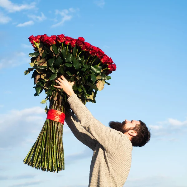 男人带着一束玫瑰花 留胡子的男人捧着一大束红玫瑰 向男朋友求婚 浪漫的家伙庆祝情人节 — 图库照片