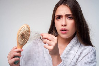 Saçını taramış, saçları sorunlu bir kadın. Saç dökülmesi stresli kadın ve kel problemleri