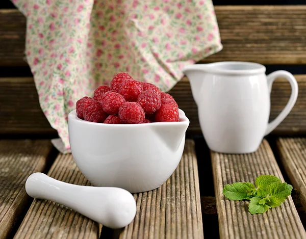 Raspberries in a white jug with mint — Stock Photo, Image