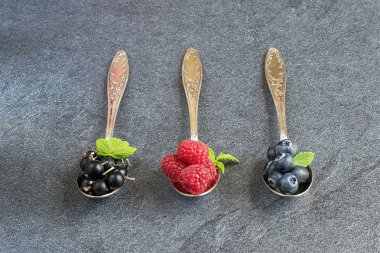 gri zemin üzerine kaşık yaz meyveleri