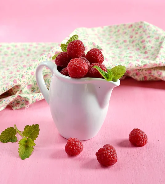 Ripe raspberries in a white jug with mint — Stock Photo, Image