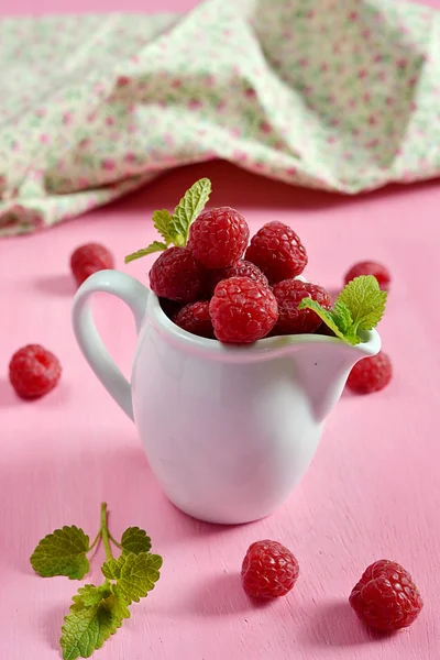 Raspberries in a white jug with mint — Stock Photo, Image