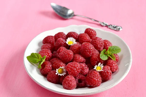 Raspberries in a white plate with mint — Stock Photo, Image