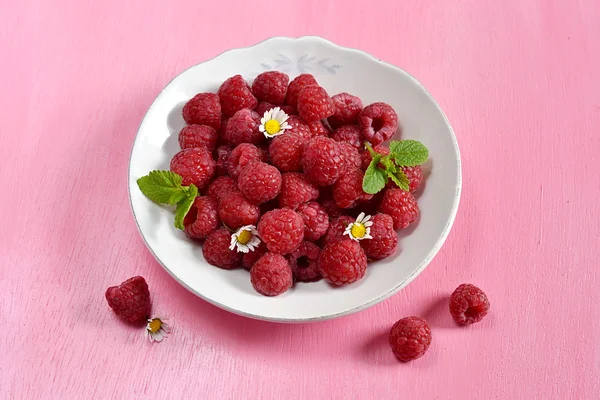 Raspberries in a white plate with mint — Stock Photo, Image