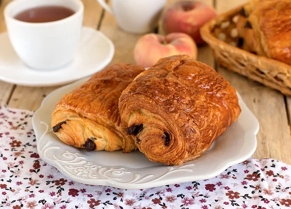 チョコレート クロワッサンの朝食の茶とプレート — ストック写真