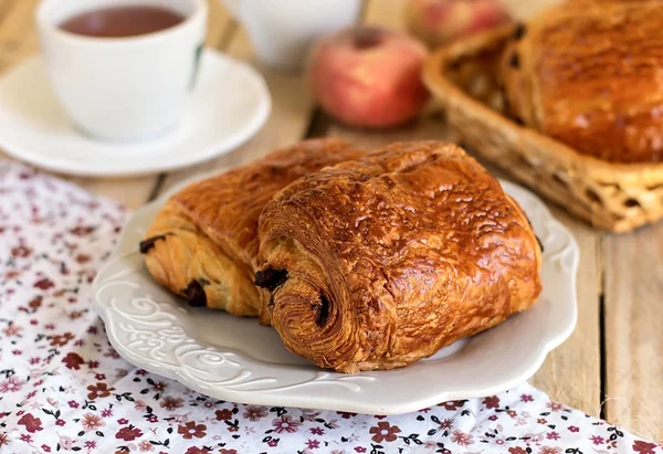 チョコレート クロワッサンの朝食の茶とプレート — ストック写真