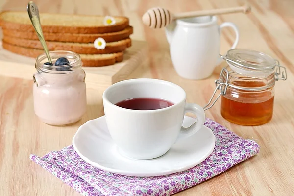 Frukost med te, honung, blåbär och yoghurt — Stockfoto