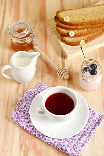 Breakfast with tea, honey, blueberries and yogurt — Stock Photo, Image