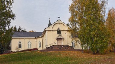Finlandiya 'nın Askola kentindeki Luteryan Kilisesi: sonbahar, renkli ağaçlar, güneşli gün.