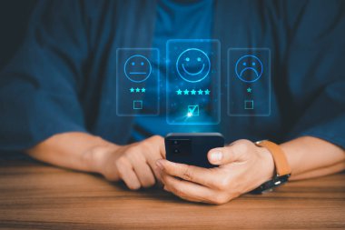 Uygulamada akıllı telefon kullanan bir adam servis deneyimine not verir. Çevrimiçi müşteri memnuniyet geri bildirim anketi.