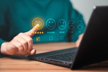 Dizüstü bilgisayar kullanan bir adam başvurudaki hizmet deneyimine not veriyor. Çevrimiçi müşteri memnuniyet geri bildirim anketi.